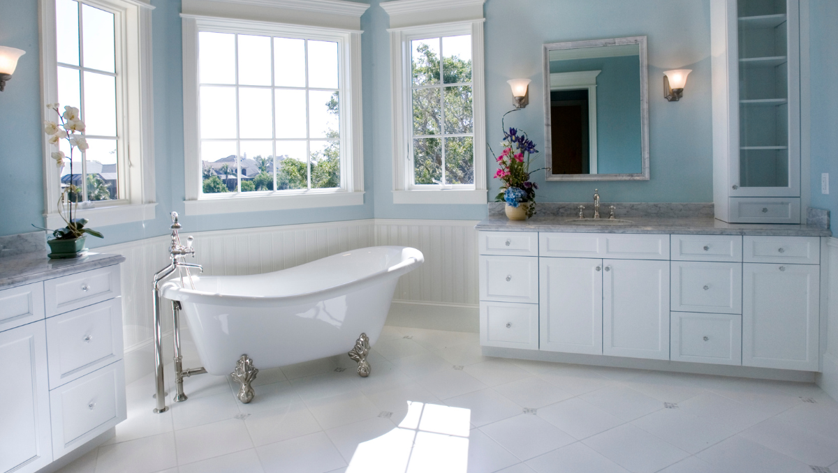 Custom bathroom remodel in St. Michaels, MD by BCO Construction featuring freestanding tub, marble vanity, and large windows for natural light.