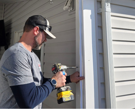 BCO carpenter installing exterior trim on residential home in Maryland using power tools