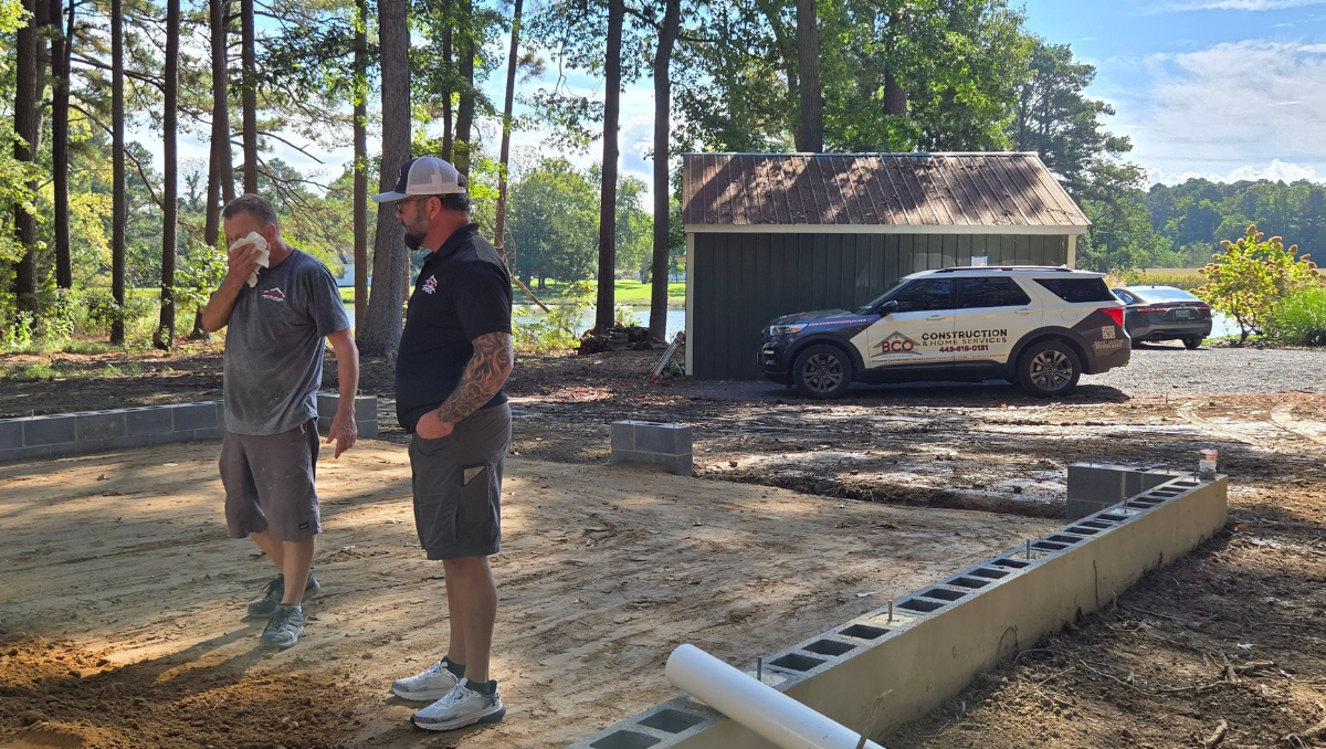Contractors reviewing foundation layout at start of custom garage build project in Royal Oak Maryland