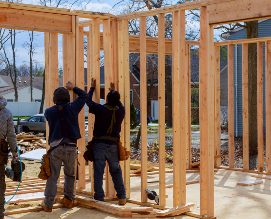 Construction crew framing a residential structure with wooden beams on a job site in Maryland