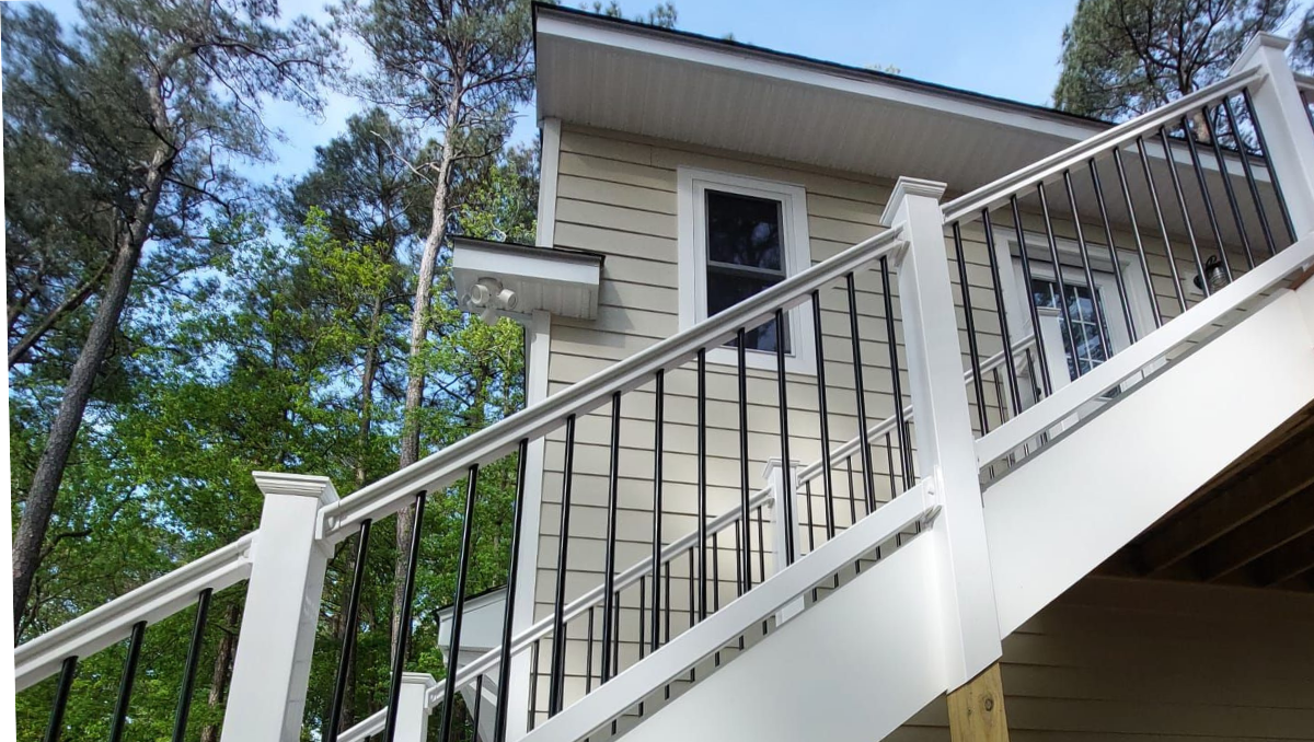 Custom-built exterior staircase and elevated deck with white railing and black balusters installed at the Royal Oak home on Maryland’s Eastern Shore.