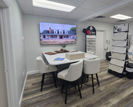 Private design consultation area inside the BCO Home & Outdoor Living Showroom with product displays and large presentation screen.