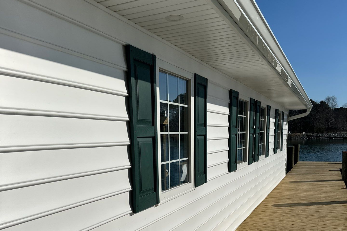 Newly installed windows with dark shutters on a waterfront home